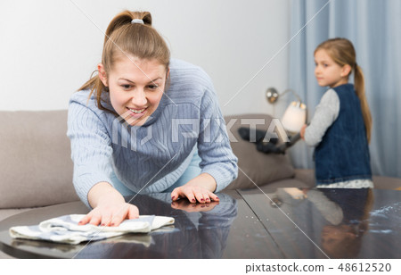 Woman with vacuum cleaner and daughter with rag Woman with vacuum cleaner and daughter with rag 48612520