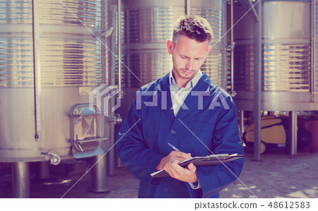 young friendly man working in winery and taking notes young friendly man working in winery and taking notes 48612583