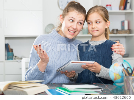 Girl and mother doing home task Girl and mother doing home task 48612600