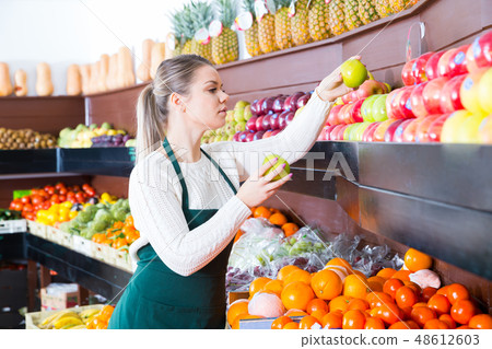 Young female in apron fresh apples and fruits 48612603