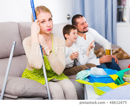 Upset woman with cleaning equipment 48612675