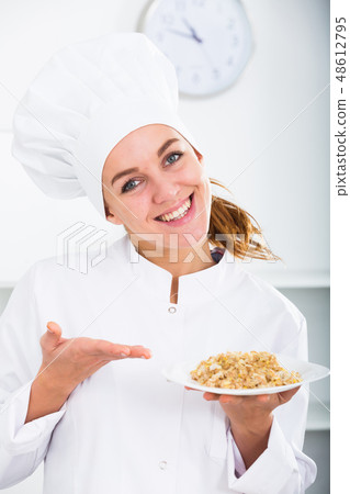 Girl cook shows plate of porrige 48612795