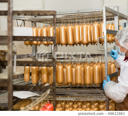 Female carrying sausages on racks 48612861