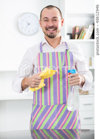 Young man in apron cleaning table Young man in apron cleaning table 48612946