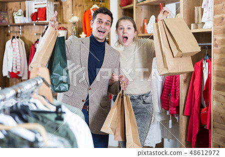 Young woman and man are standing satisfied with packadge after shopping Young woman and man are standing satisfied with packadge after shopping 48612972