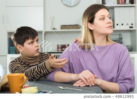 Small boy wants to make peace with his mother after arguing at table Small boy wants to make peace with his mother after arguing at table 48612993