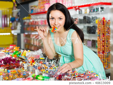 sexy satisfied female posing in the store with lolly 48613009
