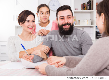 Parents signing property papers 48613012