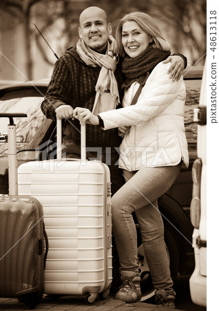 Senior smiling pleasant couple of travellers posing with trollers 48613118