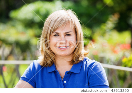 Portrait of mature woman standing in garden 48613290