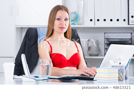 Woman in red bra on laptop Woman in red bra on laptop 48613321