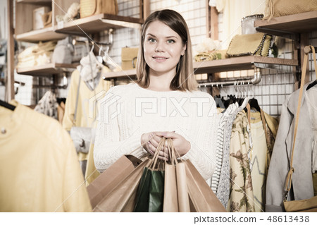 Woman carrying paper bags with purchases in fashion store Woman carrying paper bags with purchases in fashion store 48613438