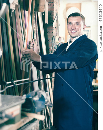 friendly male seller in picture framing studio with wooden details friendly male seller in picture framing studio with wooden details 48613440
