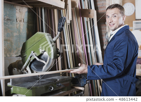 Man operating circular saw in wood workshop 48613442