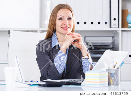 Cheerful businesswoman at workplace 48613769