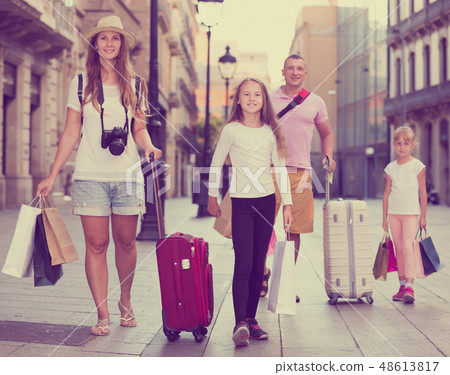 Active family of tourists walking with suitcases Active family of tourists walking with suitcases 48613817
