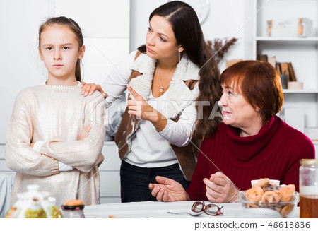 Upset girl scolded by mother and grandma 48613836