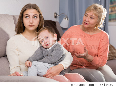Two adult female are having disagreements with upbringing kid Two adult female are having disagreements with upbringing kid 48614059