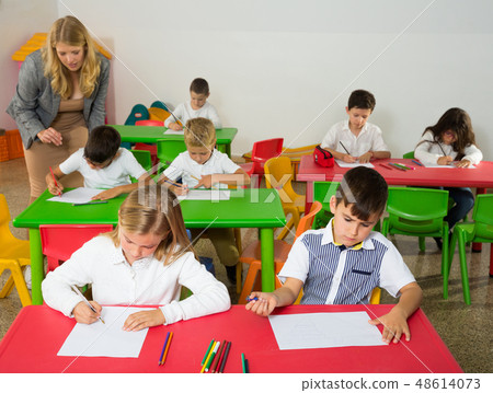 Female teacher and pupils working in classroom Female teacher and pupils working in classroom 48614073