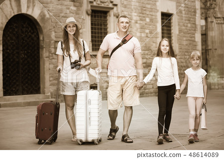 Cheerful family walking with suitcases Cheerful family walking with suitcases 48614089