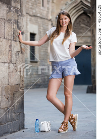 Young woman standing near old stone wall Young woman standing near old stone wall 48614329