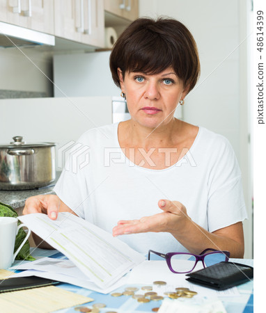 sad woman paying bills 48614399