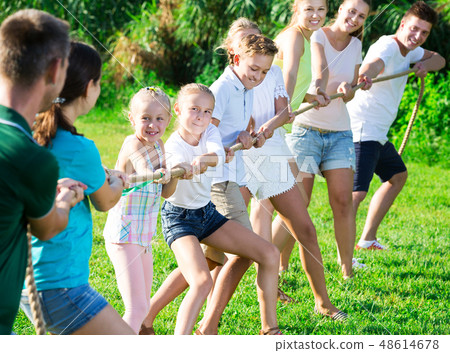 people with kids having fun outdoors pulling rope 48614678