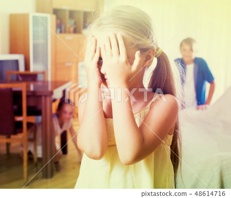 Teenage boy with sisters playing hide-and-go-seek Teenage boy with sisters playing hide-and-go-seek 48614716