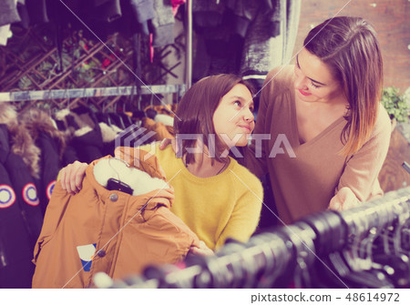Mother and daughter choosing warm coat 48614972