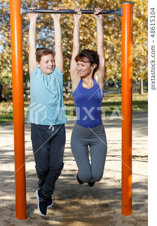 Family doing exercises on horizontal bar Family doing exercises on horizontal bar 48615104