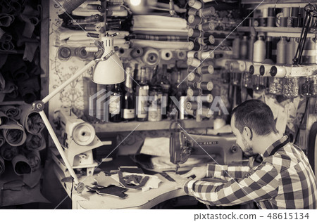 Male worker stitching new belt 48615134