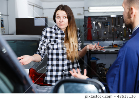 Young woman is disappointed of tire replacement of her car in spring Young woman is disappointed of tire replacement of her car in spring 48615136