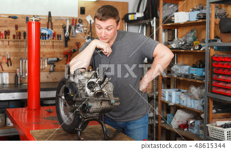 Man mechanic repairing modern moto 48615344