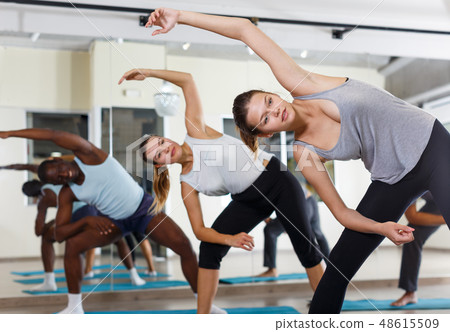 Happy people exercising during yoga class Happy people exercising during yoga class 48615509