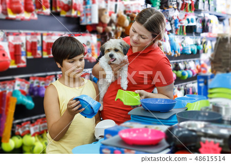 boy and his mother looking for supplies for little dog boy and his mother looking for supplies for little dog 48615514