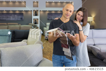 Couple choosing upholstery fabric in salon 48615515