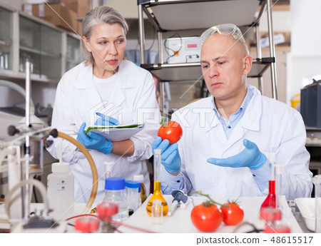 Scientists taking notes while performing experiments 48615517