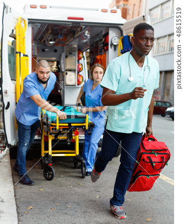 Three ambulance doctors posing in ambulance car with medical equipment Three ambulance doctors posing in ambulance car with medical equipment 48615519