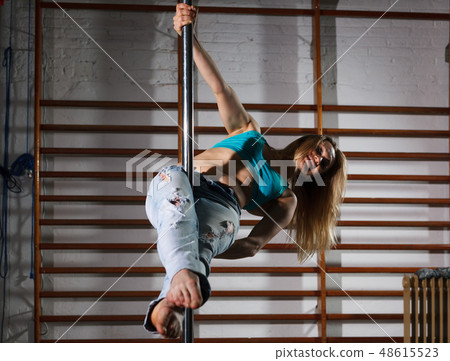Woman on pylon in lightless studio Woman on pylon in lightless studio 48615523