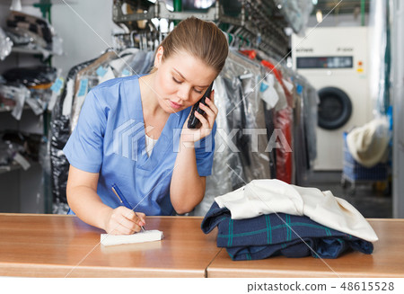 Worker of laundry talking on phone Worker of laundry talking on phone 48615528