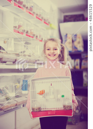 girl customer happy about buying cage with canary bird in pet shop girl customer happy about buying cage with canary bird in pet shop 48615529