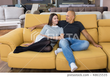 Couple sitting and testing new sofa Couple sitting and testing new sofa 48615535