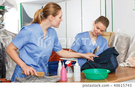 Two women working in dry cleaner Two women working in dry cleaner 48615743
