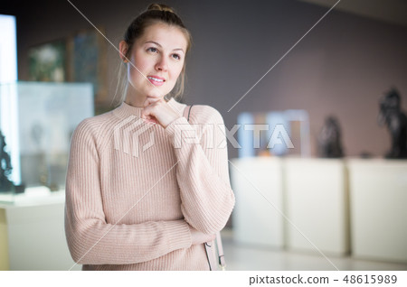 Young female visitor looking at art exhibition 48615989