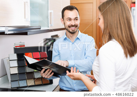 Competent seller consulting female customer in store of kitchen furnishing and appliances Competent seller consulting female customer in store of kitchen furnishing and appliances 48616022