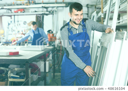 Workman is inspecting the window frame Workman is inspecting the window frame 48616104