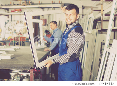 thoughtful male professional labours with finished PVC profiles and windows thoughtful male professional labours with finished PVC profiles and windows 48616118