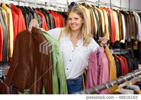Portrait of attractive woman customer with leather jackets in store Portrait of attractive woman customer with leather jackets in store 48616193