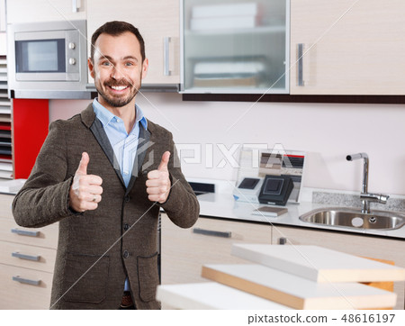 Portrait of contented bearded guy in kitchen furnishing store Portrait of contented bearded guy in kitchen furnishing store 48616197