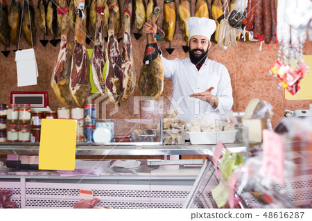 Handsome man seller showing jamon Handsome man seller showing jamon 48616287